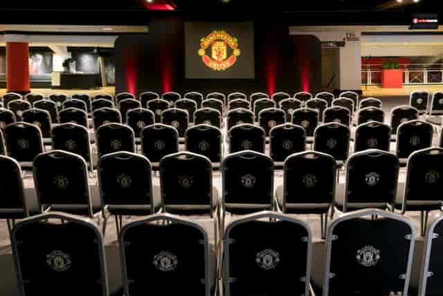 Conference event space at Old Trafford with branded chairs for corporate presentations.