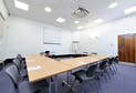 Meeting room with central table and ergonomic chairs for workshops and presentations.