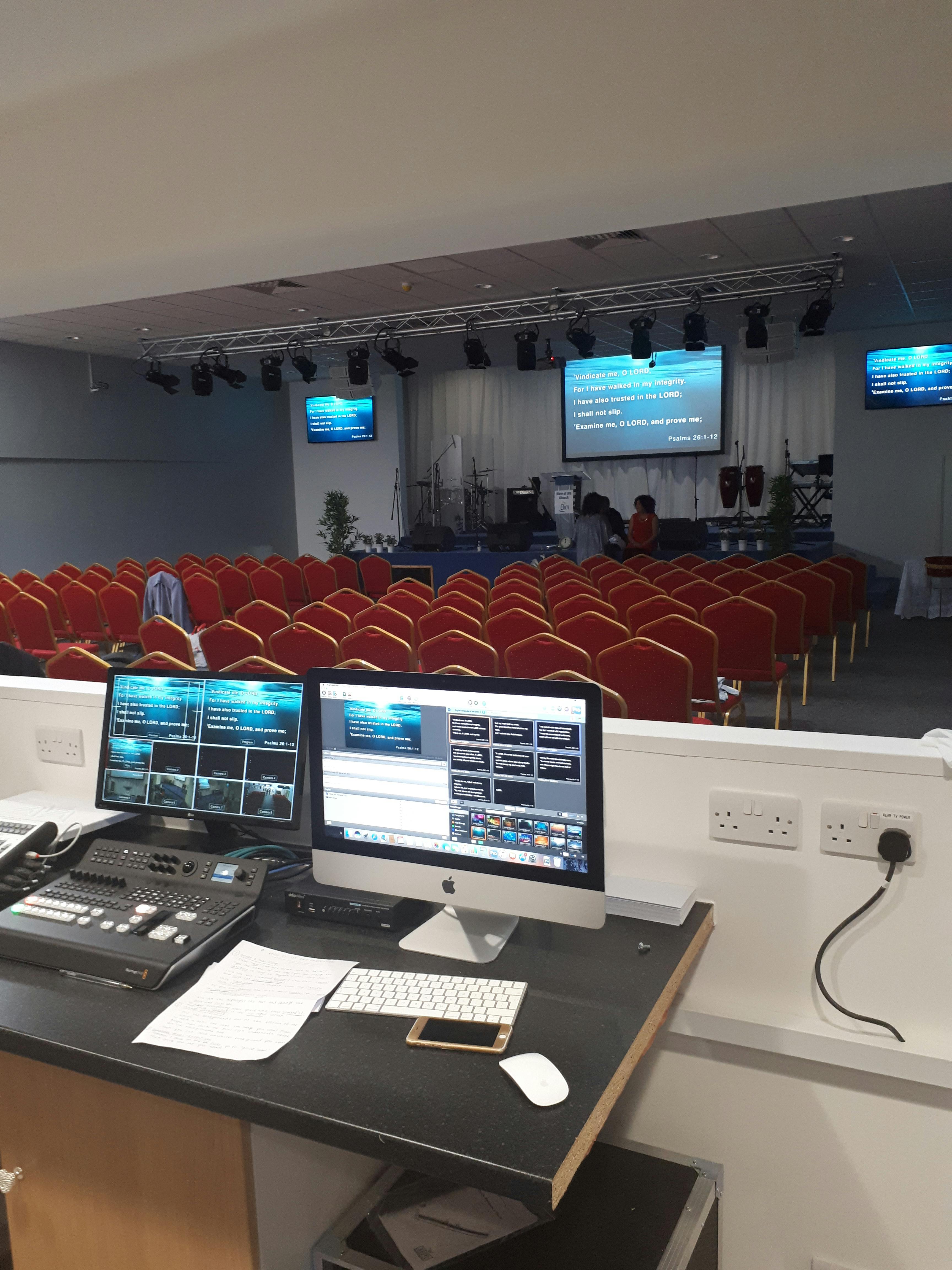 Business conference room with AV setup and red chairs for effective presentations.