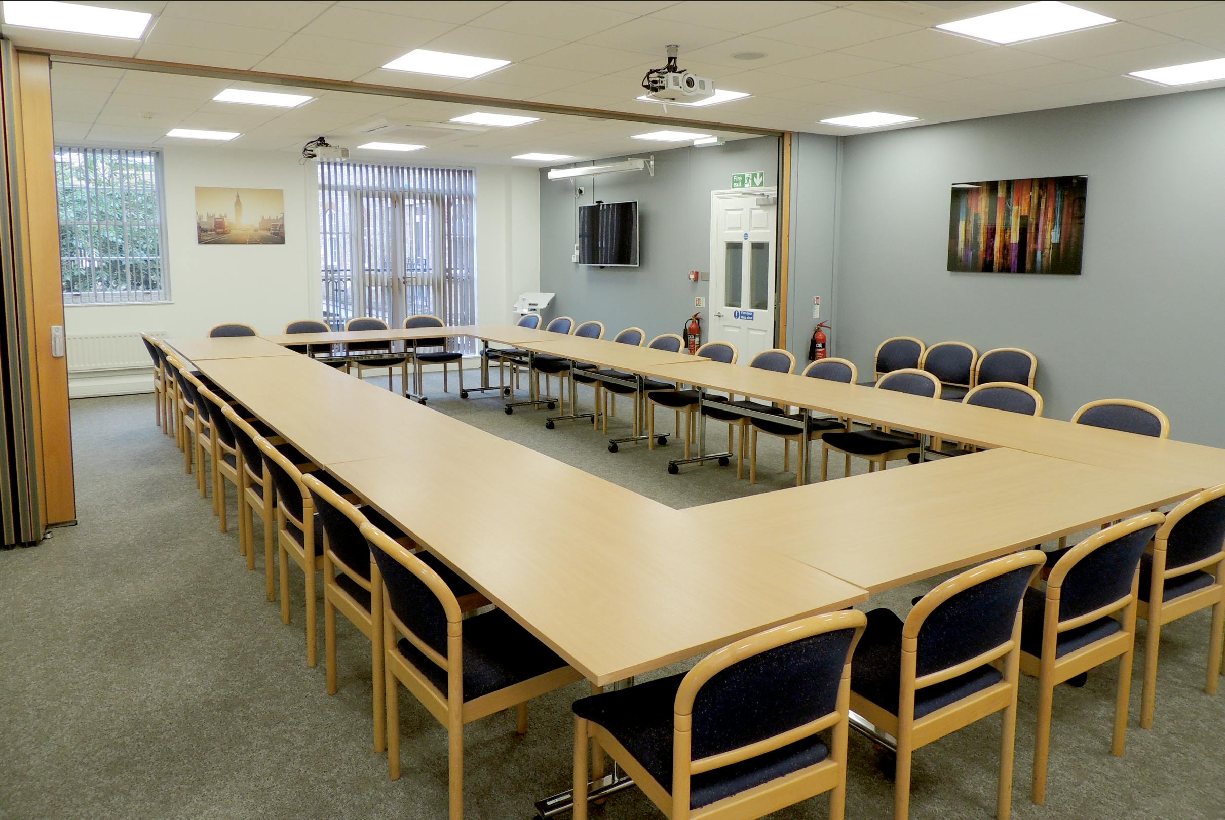 Meeting room with U-shaped table, ideal for workshops and strategic planning.