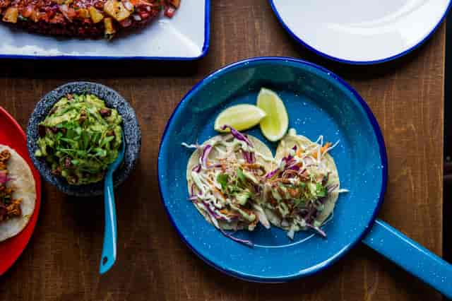 Gourmet tacos with fresh limes at Santo Remedio Tequila & Mezcal Bar for events.