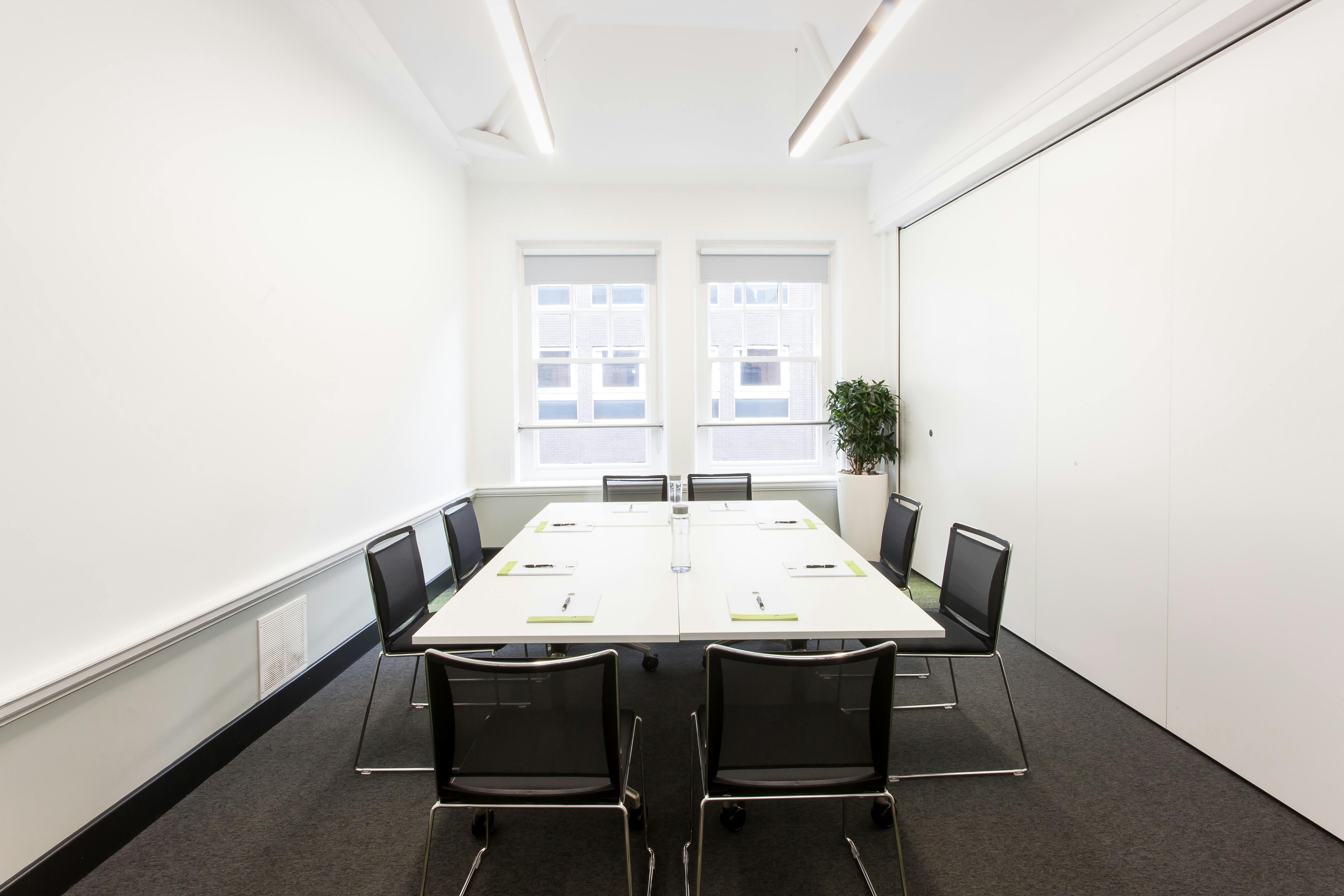 Modern minimalist meeting room with large table, ideal for brainstorming sessions.