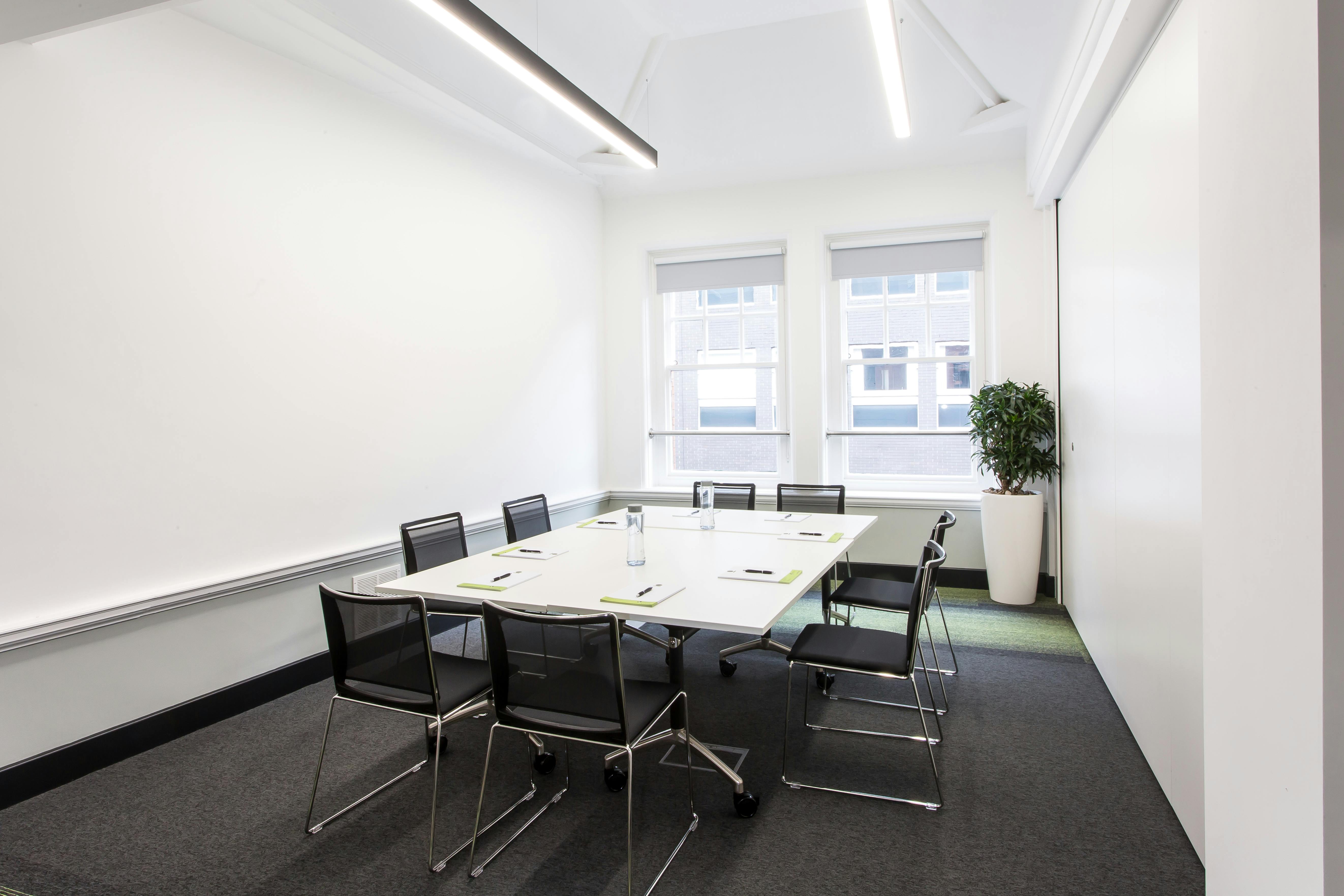 Modern meeting room with large table, ideal for brainstorming and strategic sessions.