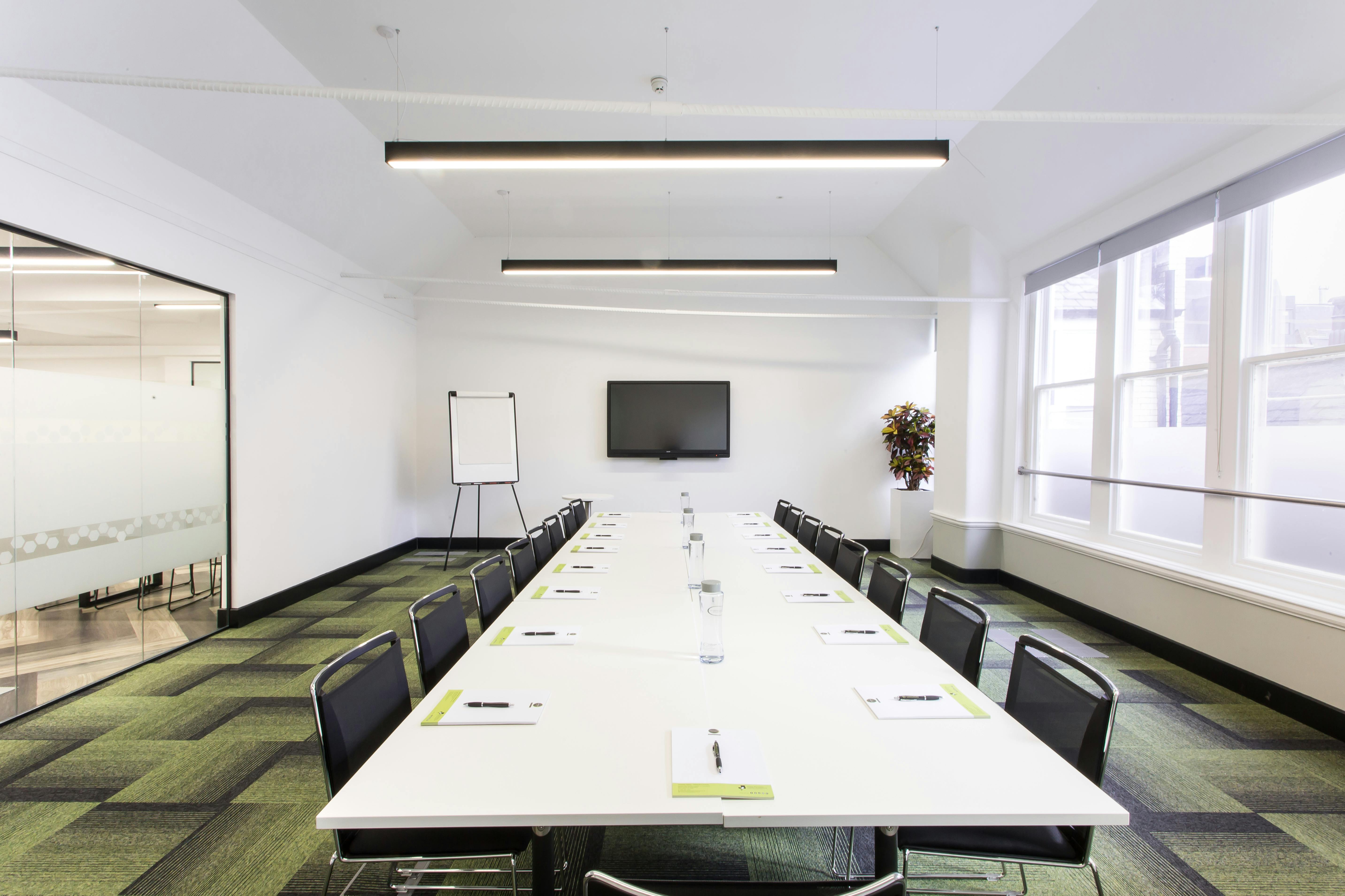 Modern training room with long table, ideal for meetings and presentations.