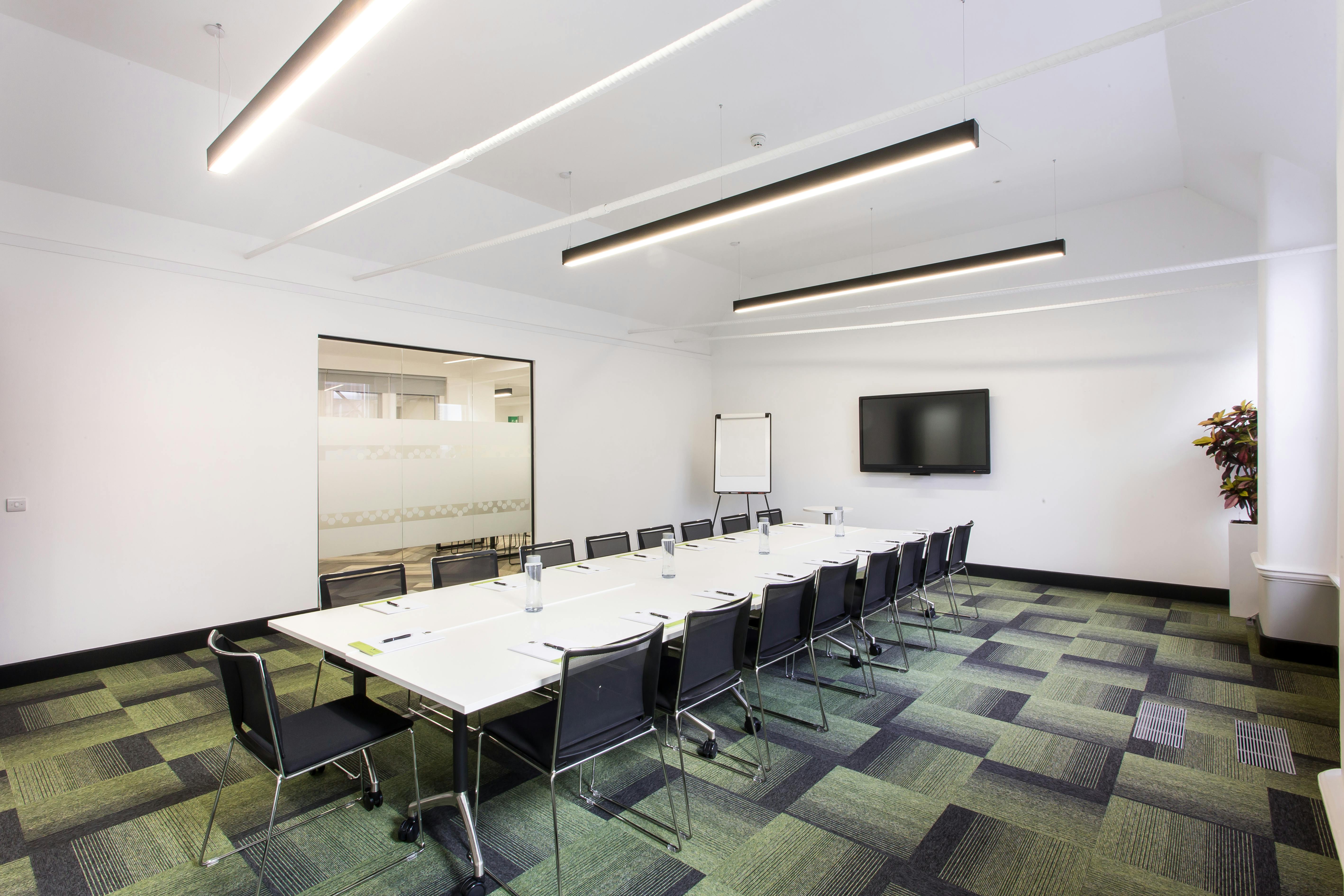 Modern conference room with long table, ideal for professional meetings and training sessions.