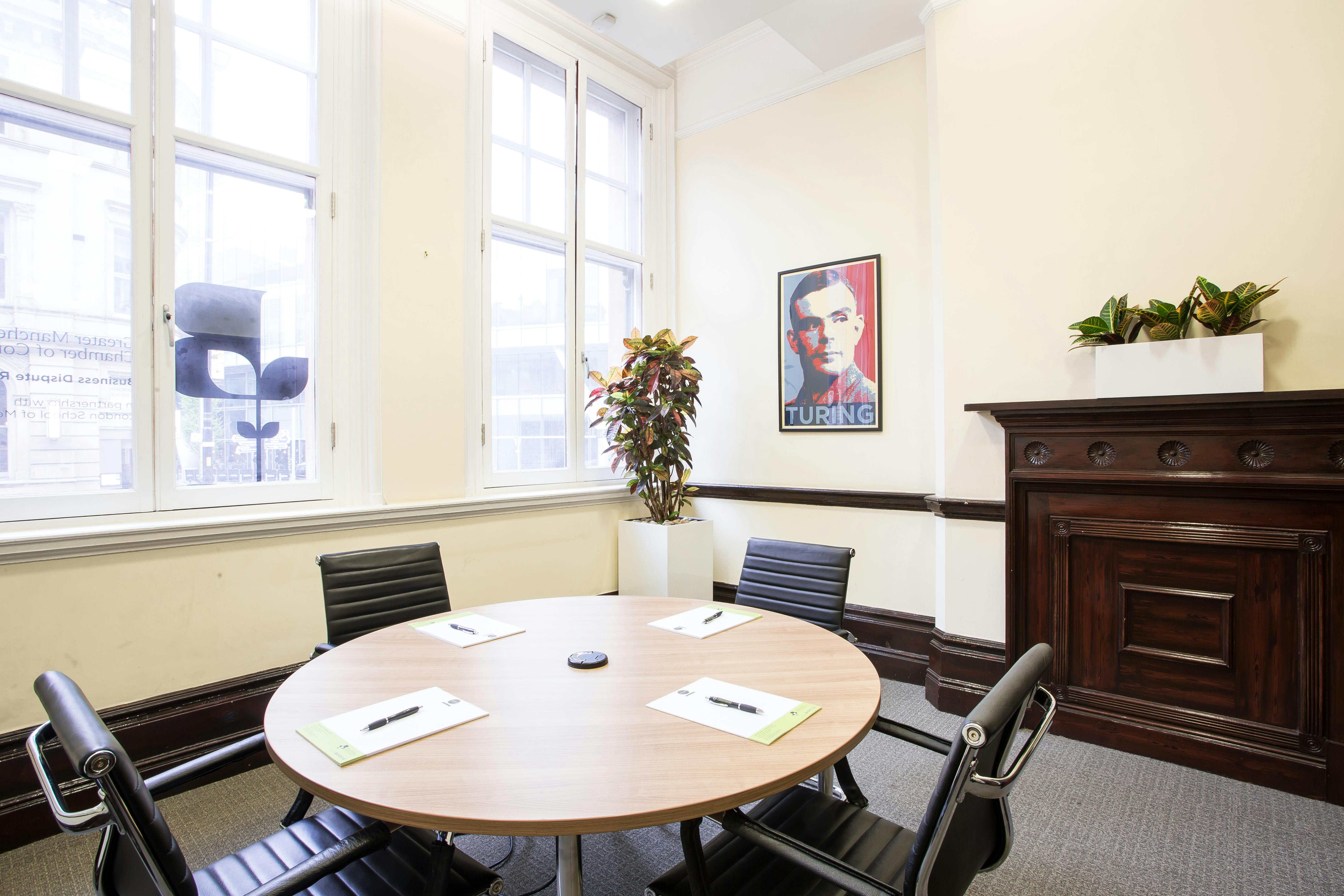 Alan Turing Room with round table, ideal for meetings and brainstorming sessions.