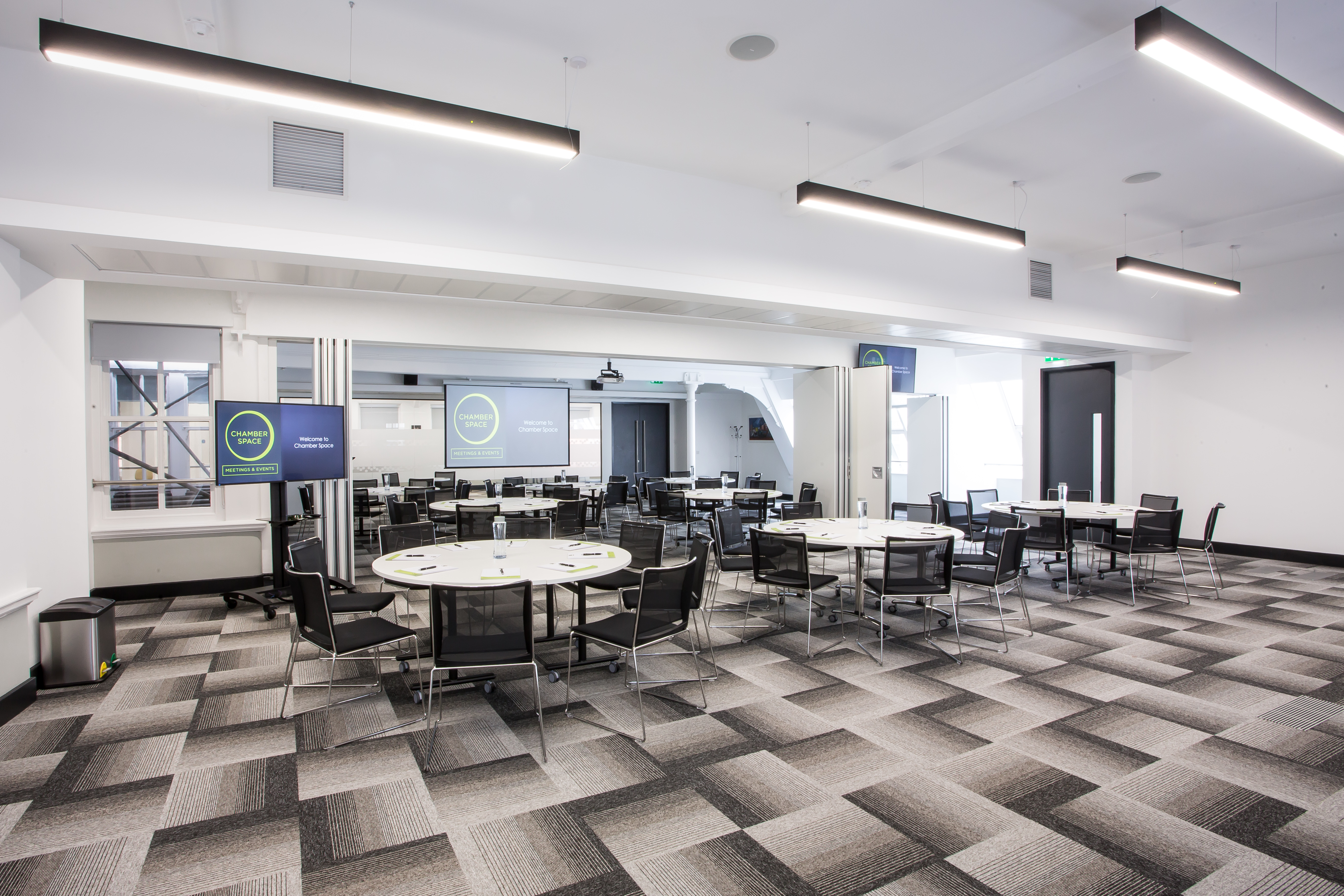 Elliot Suite meeting space with round tables, ideal for workshops and corporate events. - Banner