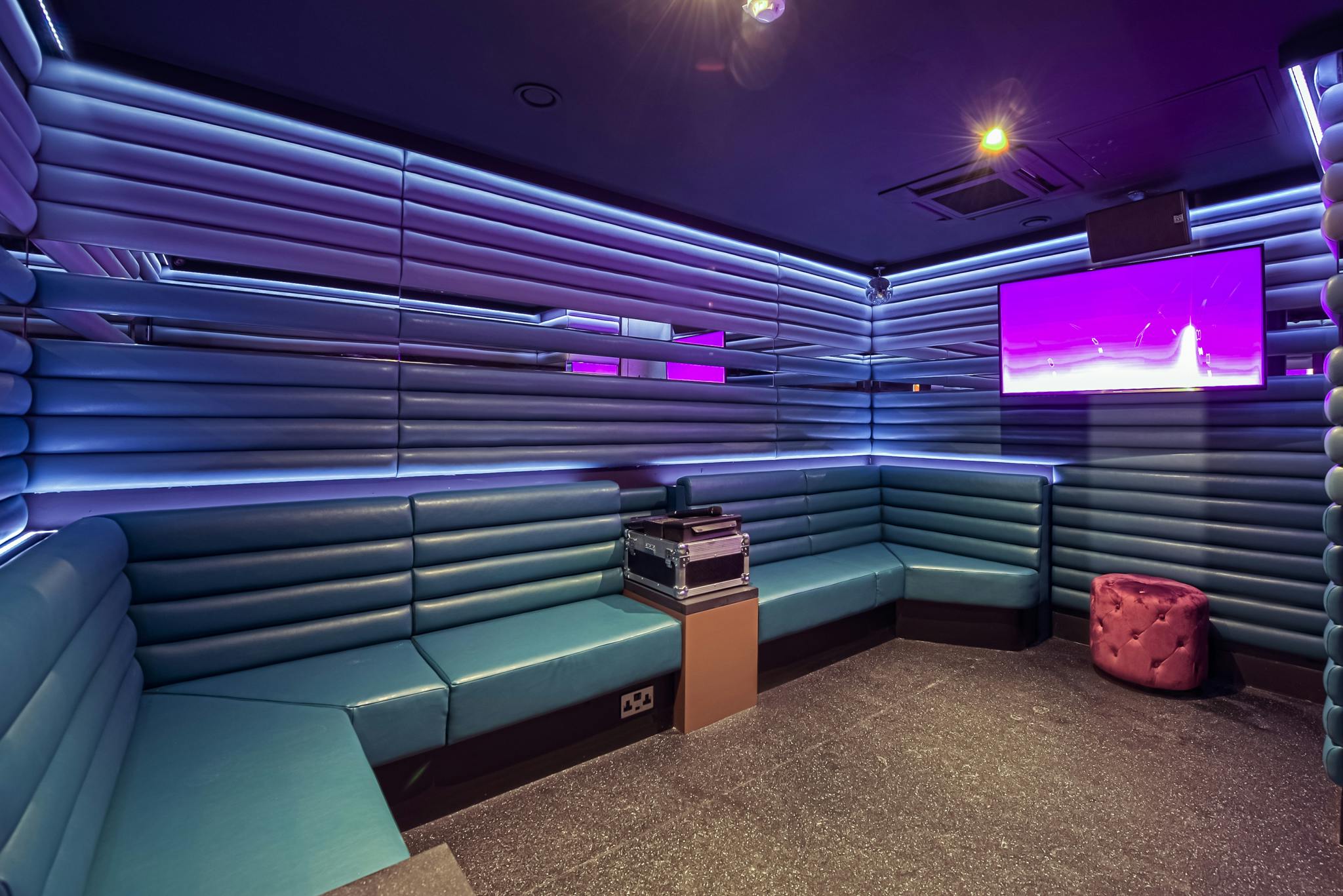 Modern private karaoke room with vibrant lighting for events and team-building activities.