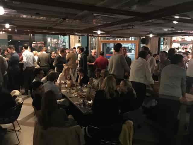 Casual networking mixer at The White Haus basement with mixed seating for corporate events.