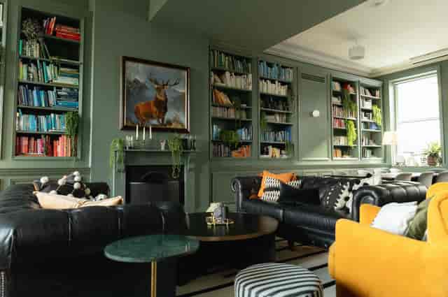 Stylish lounge in The Library, featuring green walls and cozy seating for networking events.