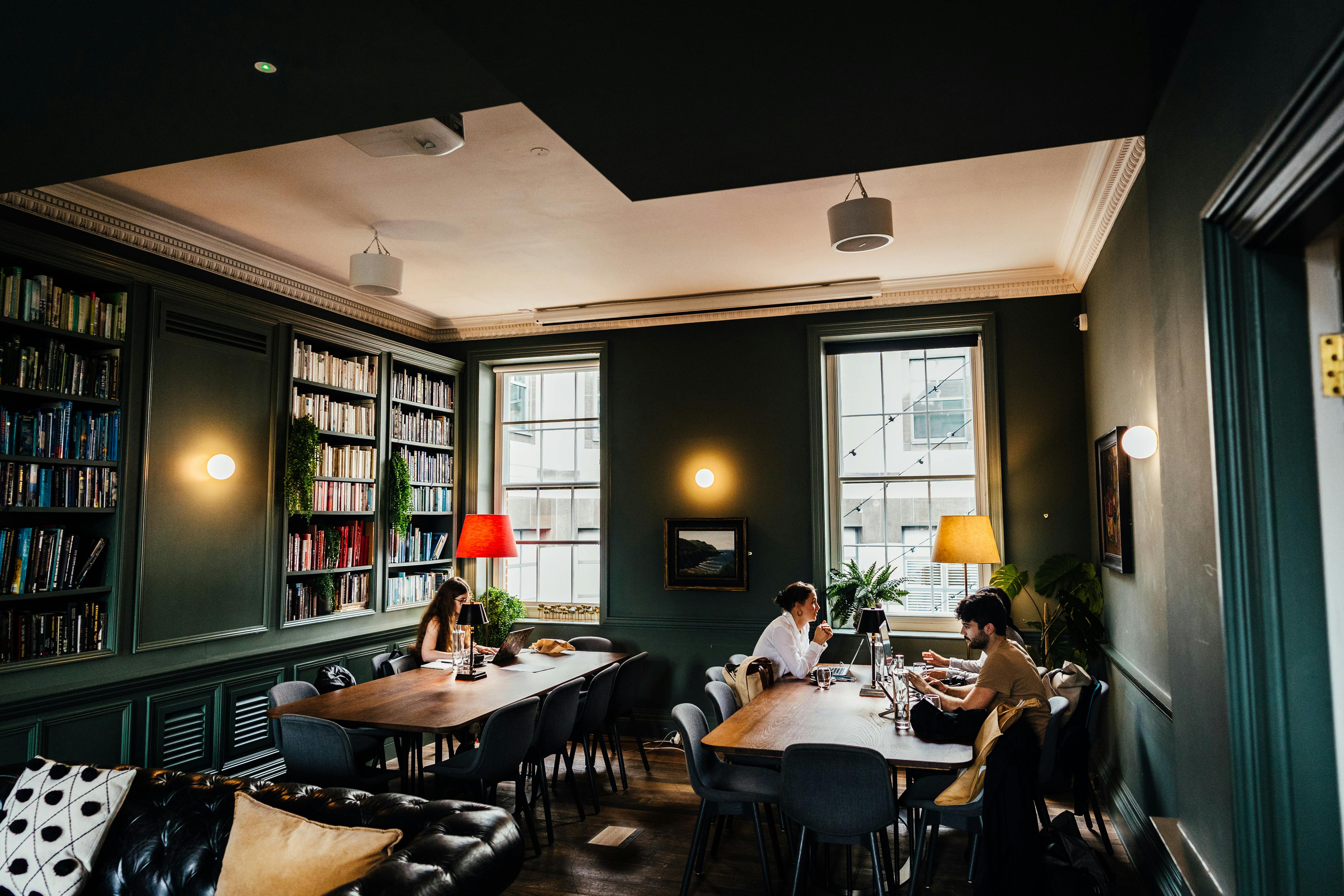 Stylish meeting space in The Library, cozy atmosphere with natural light and bookshelves.