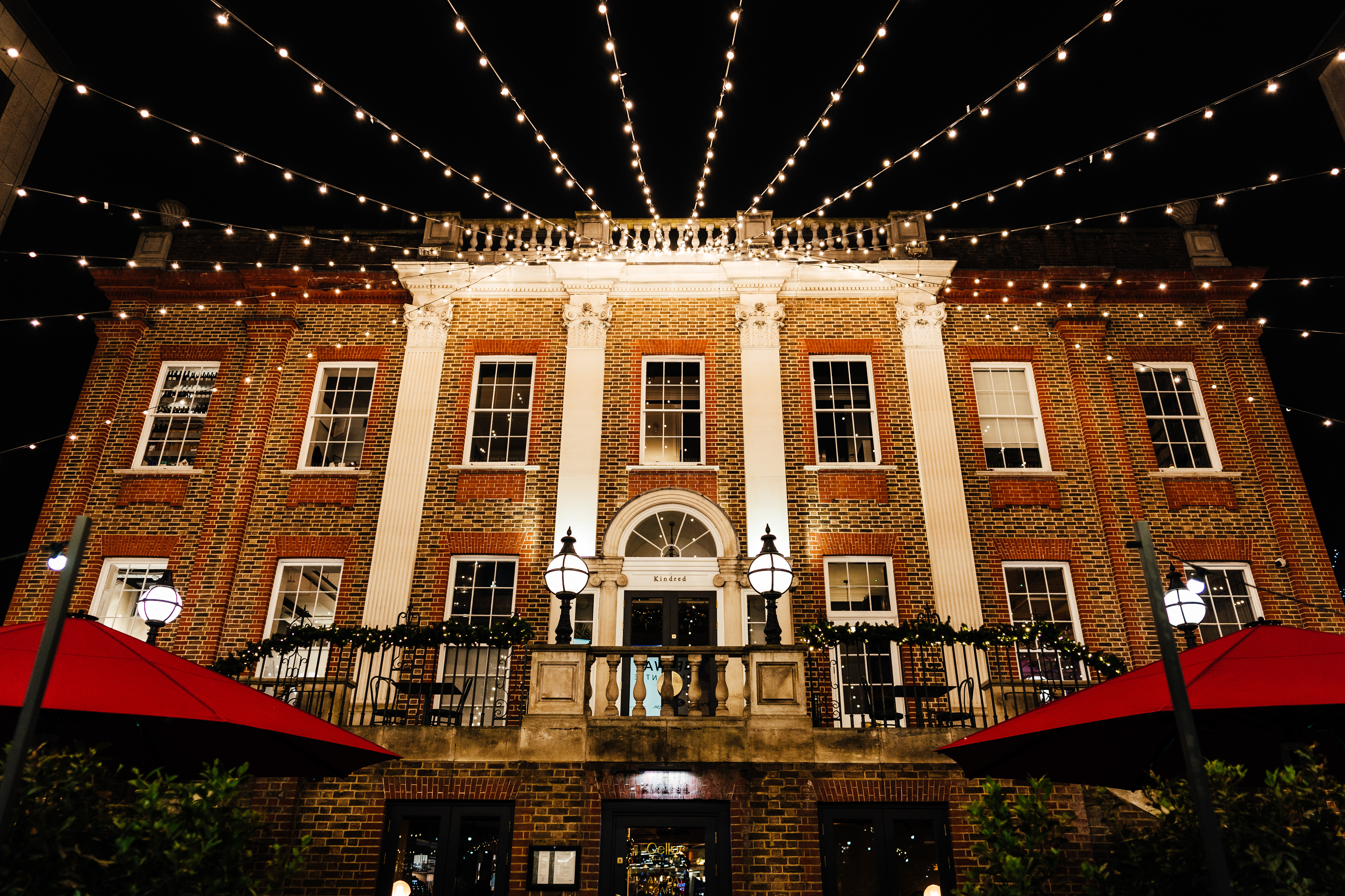 Charming outdoor library venue with string lights for evening events and receptions. - Banner