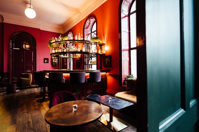 Stylish bar area with red walls, ideal for cocktail receptions and networking events.