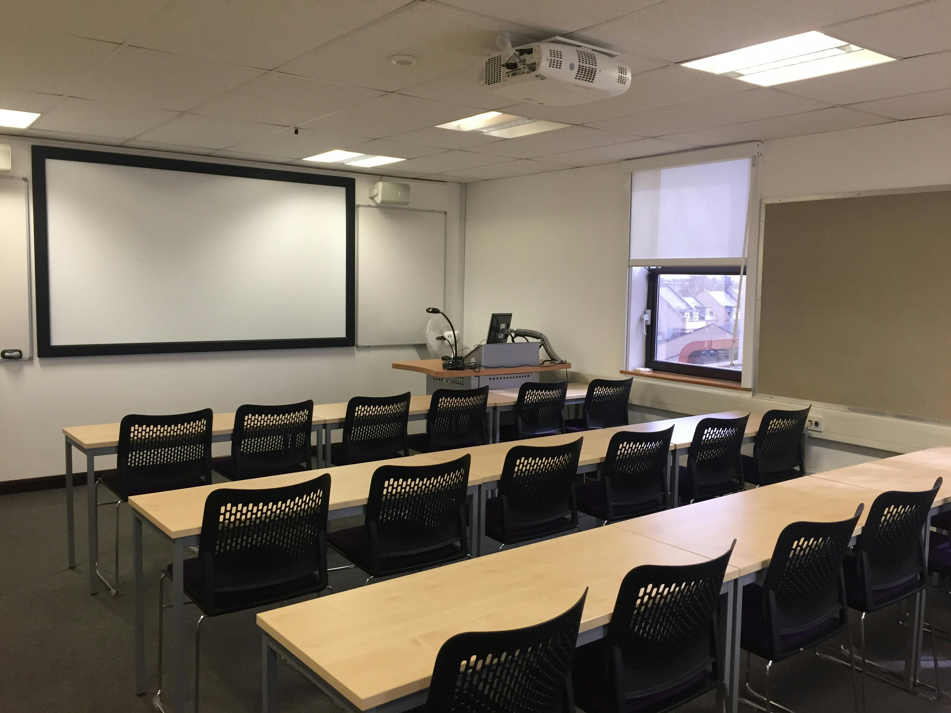 Small classroom with large screen for workshops and presentations at ARU Venue Hire, Cambridge.