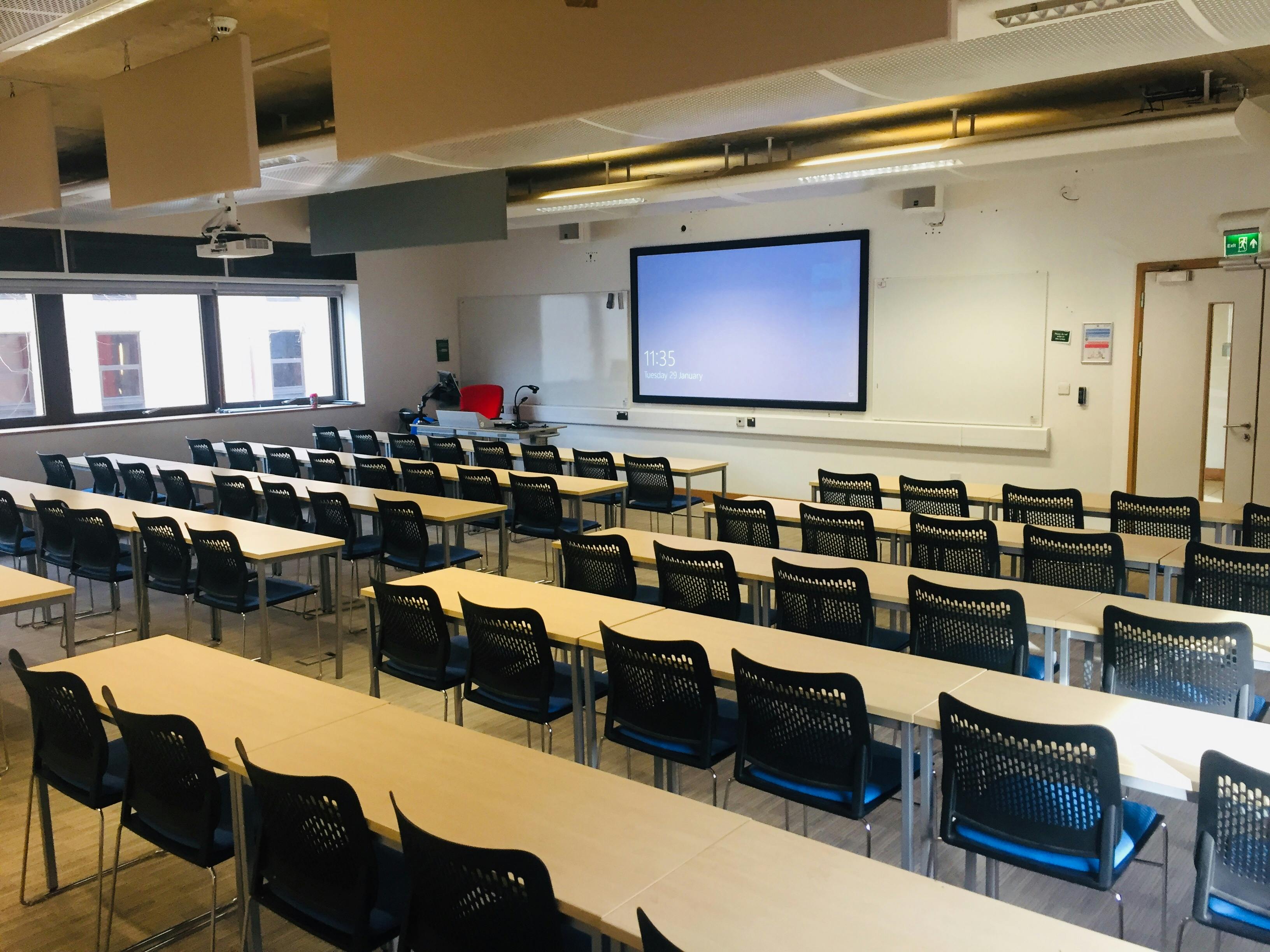 Large classroom with rows of tables, ideal for workshops and presentations in Cambridge.