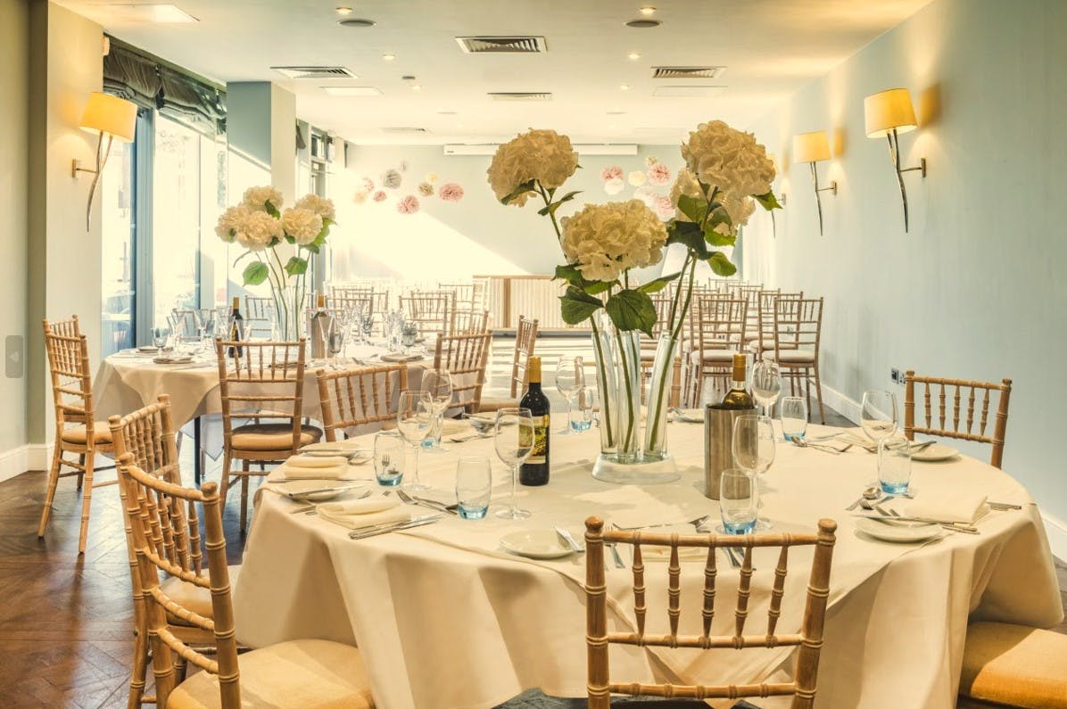 Elegant Harbour Suite 1 with floral centerpieces, ideal for corporate events and weddings.