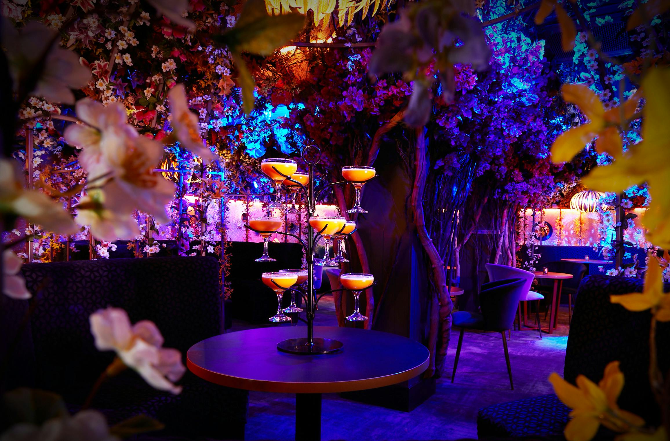 Elegant event space at Le Club, featuring floral decor and stacked cocktails for celebrations.