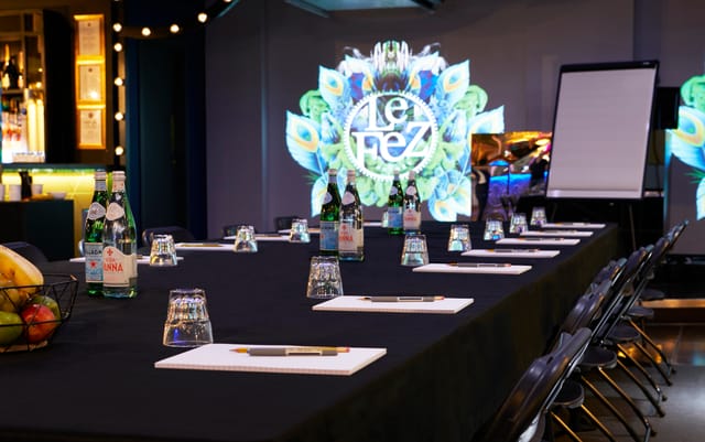 Meeting room at Le Club in Le Fez with black table, digital display, and wellness amenities.