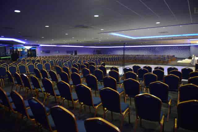 Spacious Royale Banqueting Suite with blue chairs, perfect for conferences and presentations.