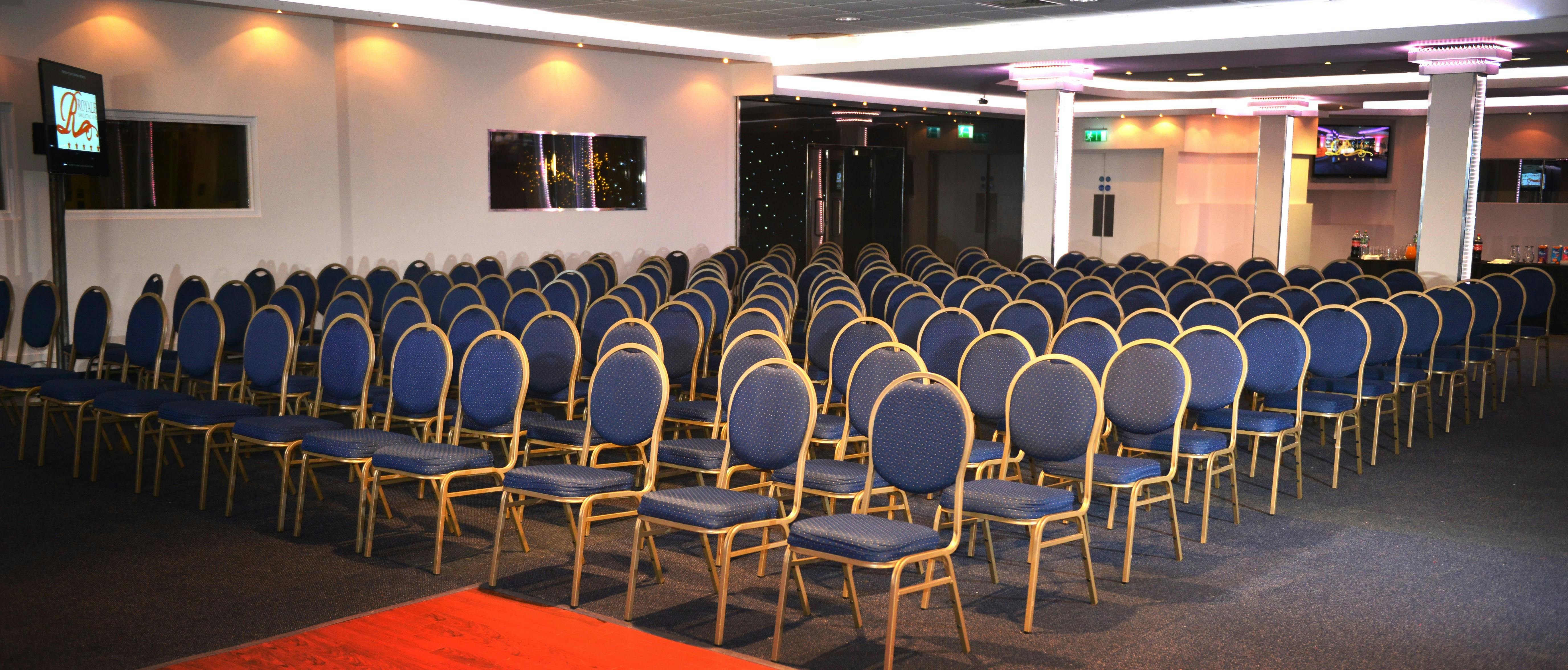 Executive lounge in Royale Banqueting Suite with blue chairs for conferences and events.