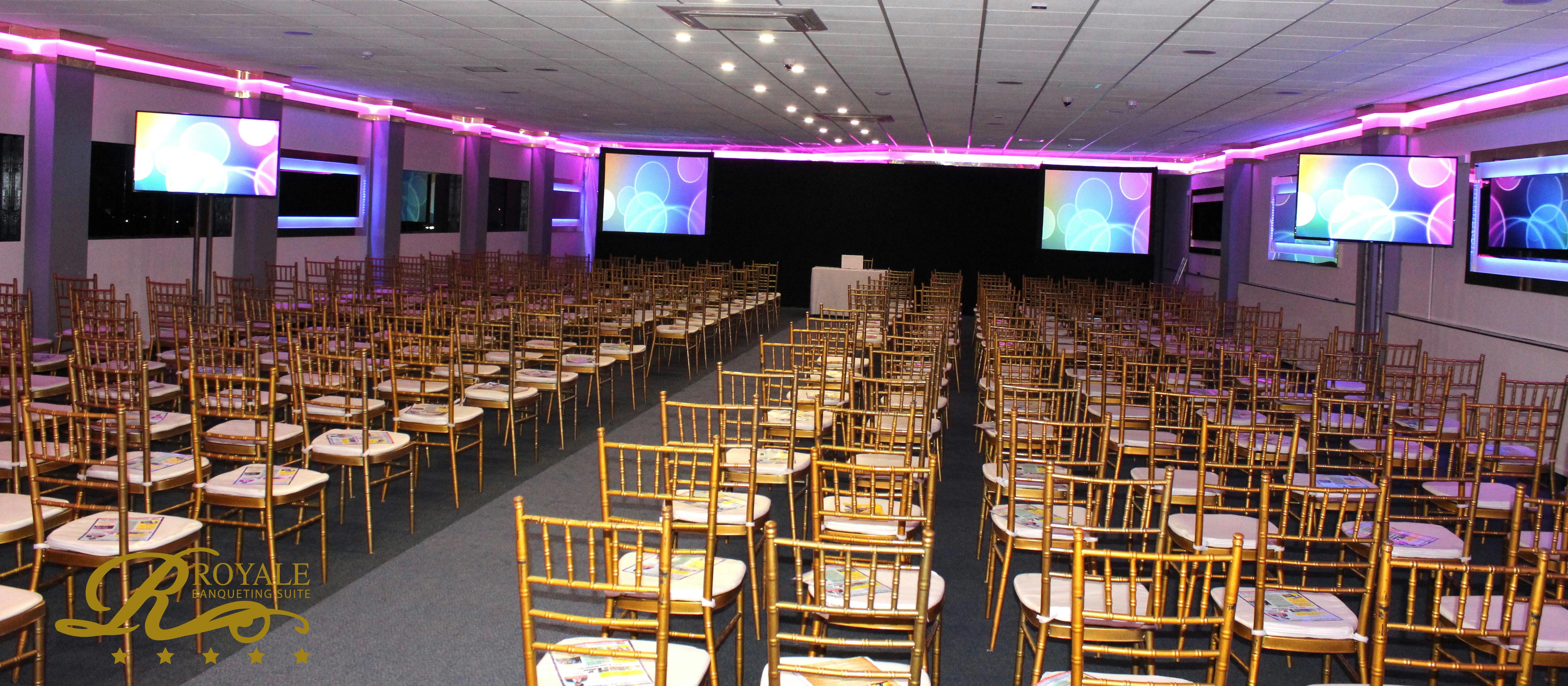 Golden Suite at Royale Banqueting, elegant chairs for a conference presentation.