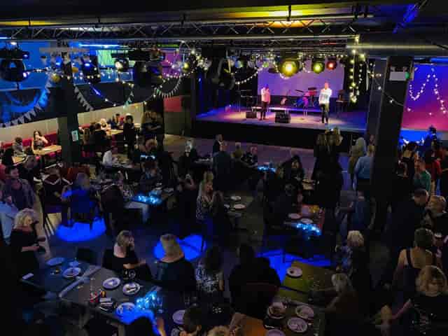 The Circle Arts Centre theatre hosting a high-energy evening reception with theatrical lighting.