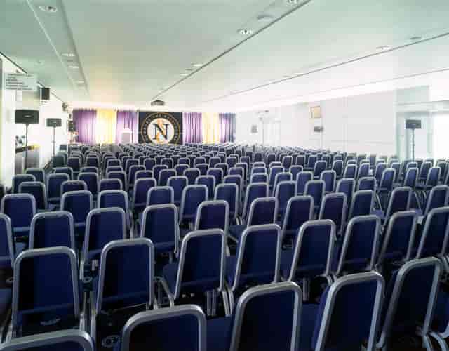 Conference room at Newbury Racecourse with blue chairs for events and presentations.