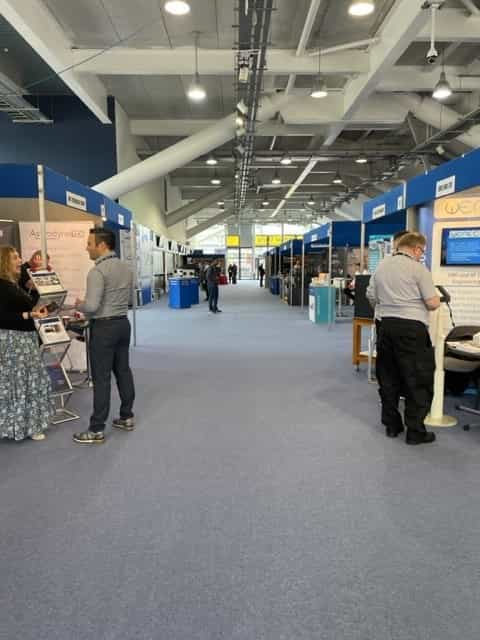 Grandstand at Newbury Racecourse, bustling exhibition hall for networking events.
