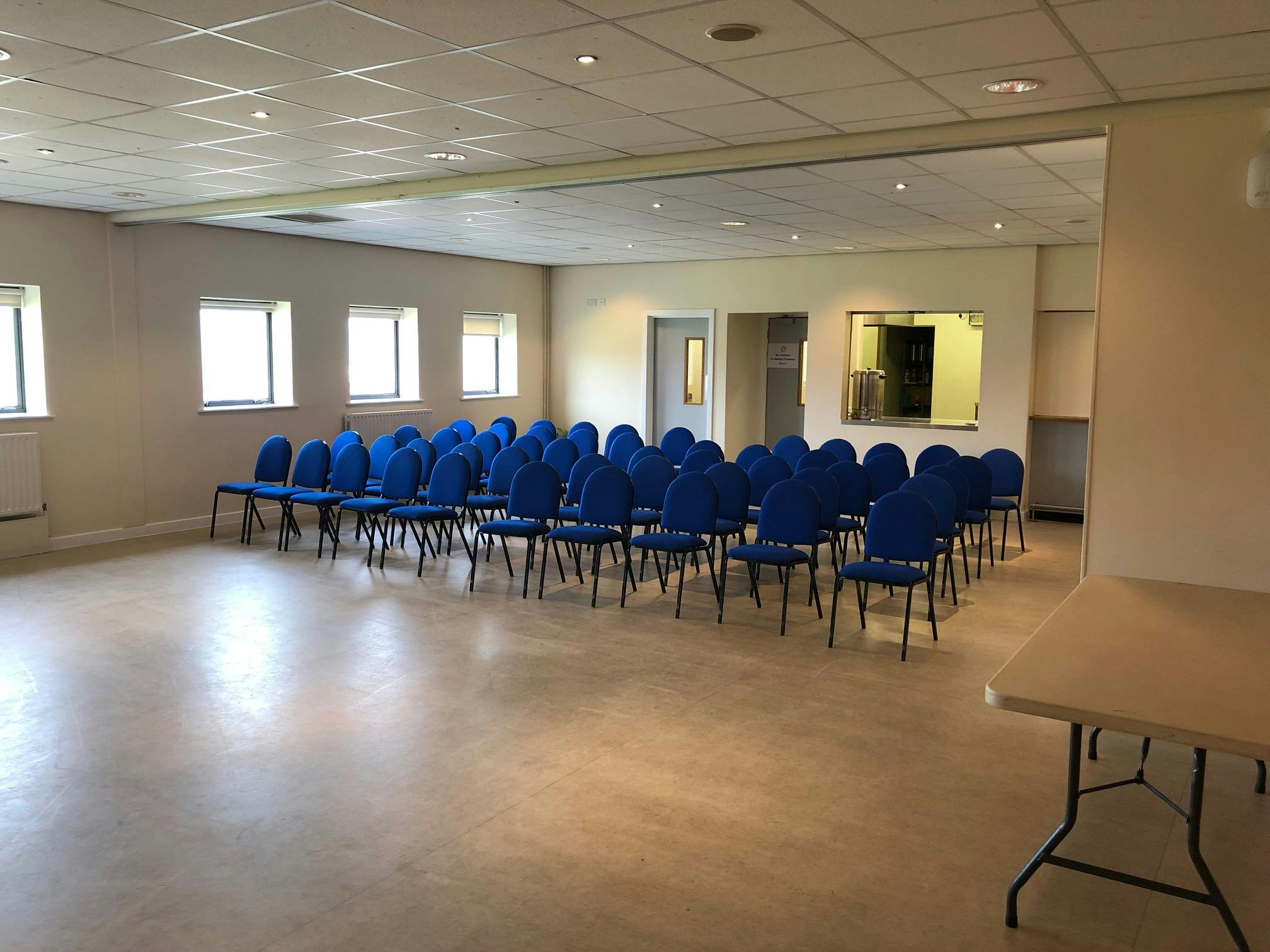 Dining area with blue chairs, ready for a seminar at DRAM Training Centre, Huddersfield.