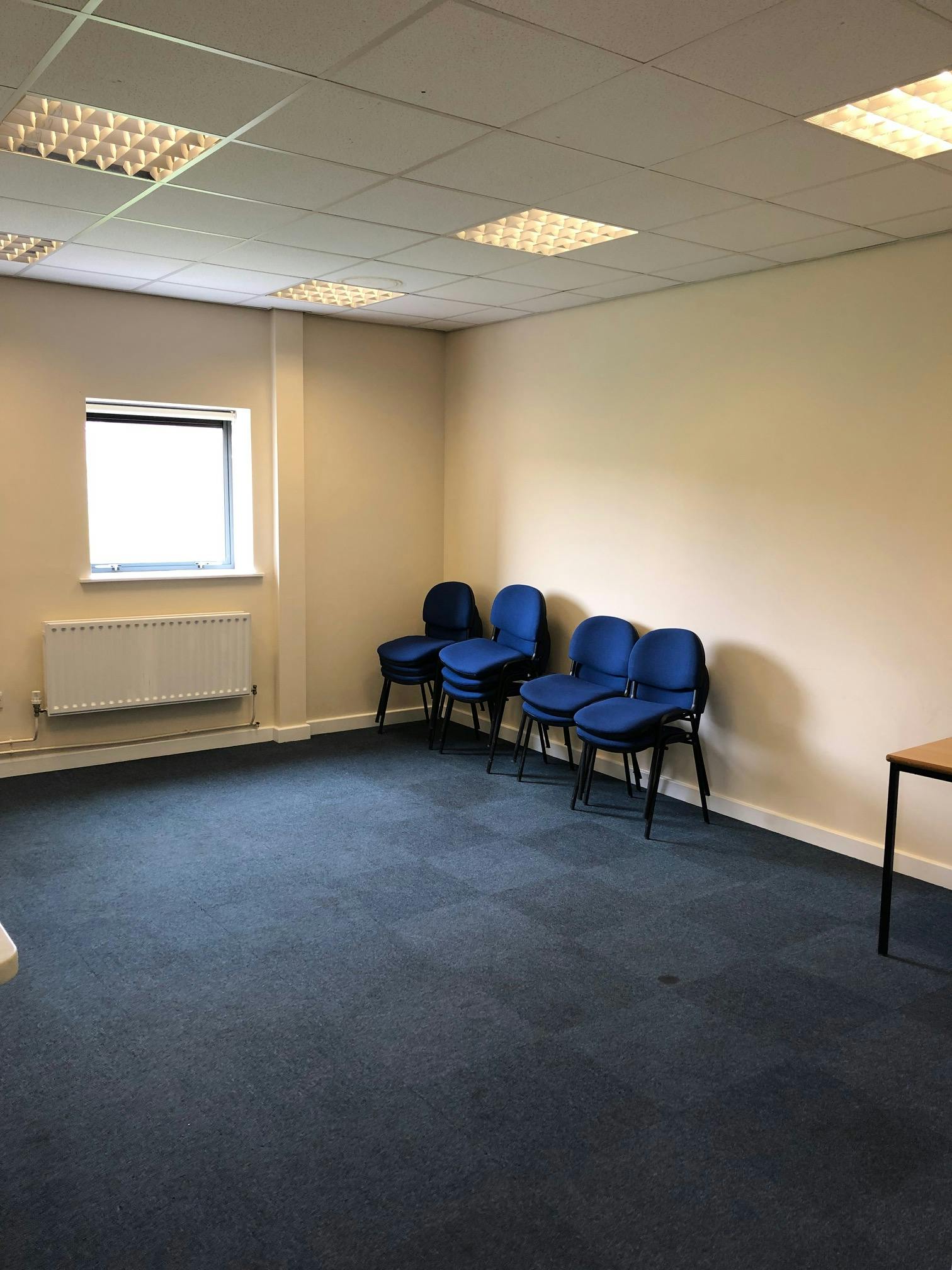 Conference room with blue chairs, ideal for meetings and brainstorming sessions.