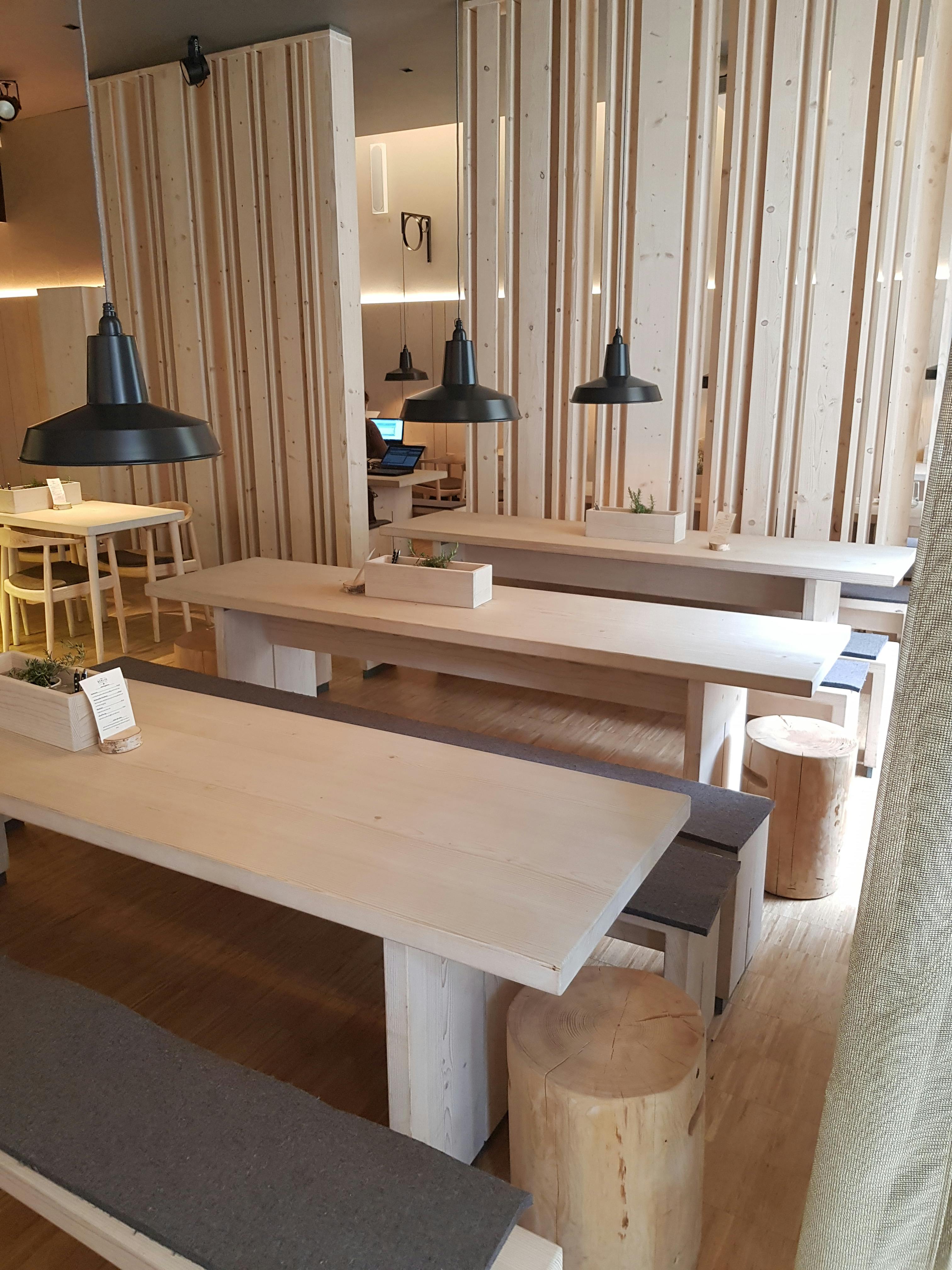 Modern function room with wooden tables, ideal for workshops and team meetings.