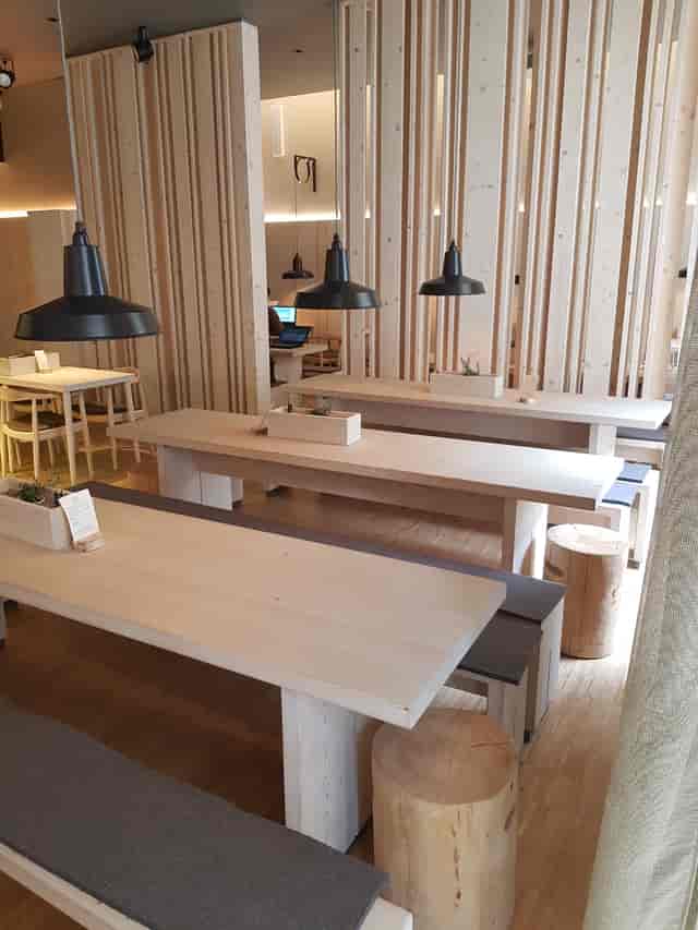 Modern function room with wooden tables, ideal for workshops and team meetings.