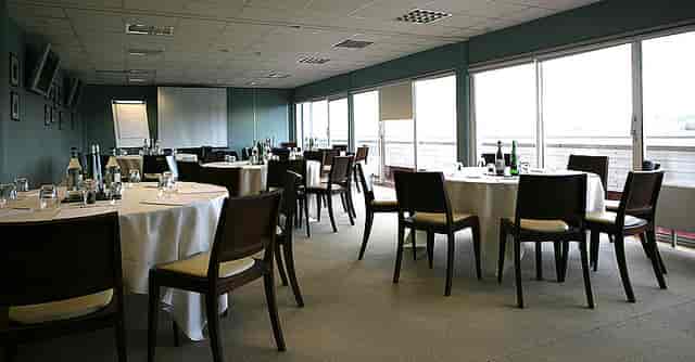 Berkshire Stand meeting space with round tables for corporate events at Newbury Racecourse.