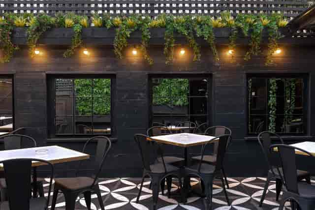 Stylish outdoor venue with greenery, ideal for networking events and gatherings.