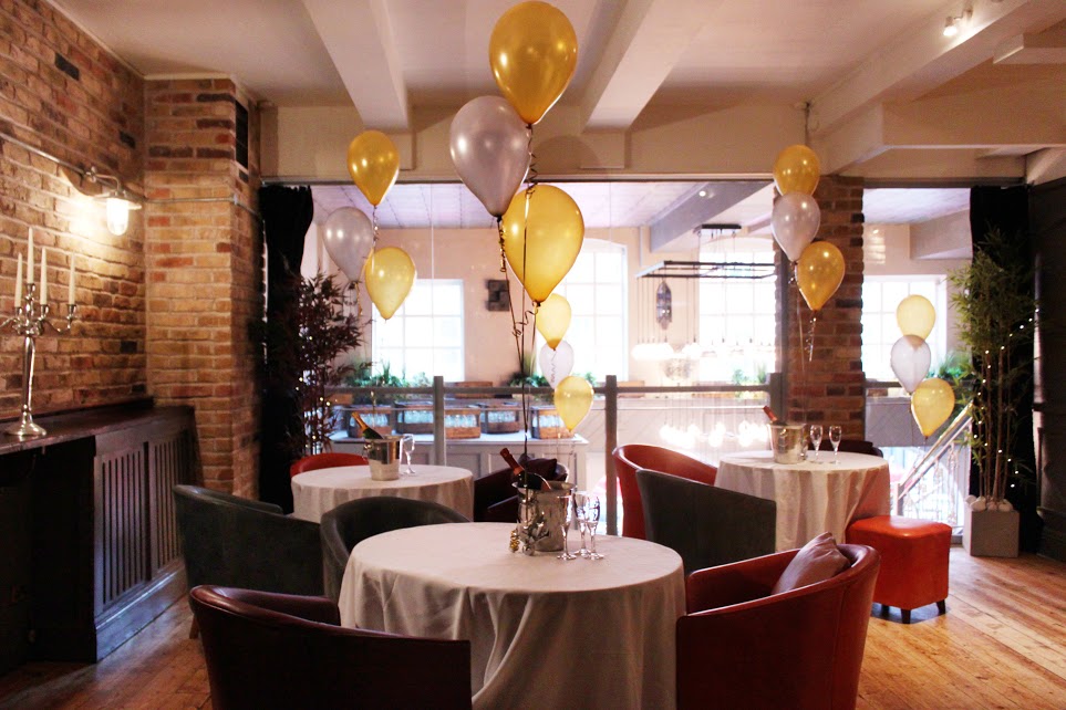 Elegant event space with white tables and colorful balloons for gatherings or celebrations. - Banner