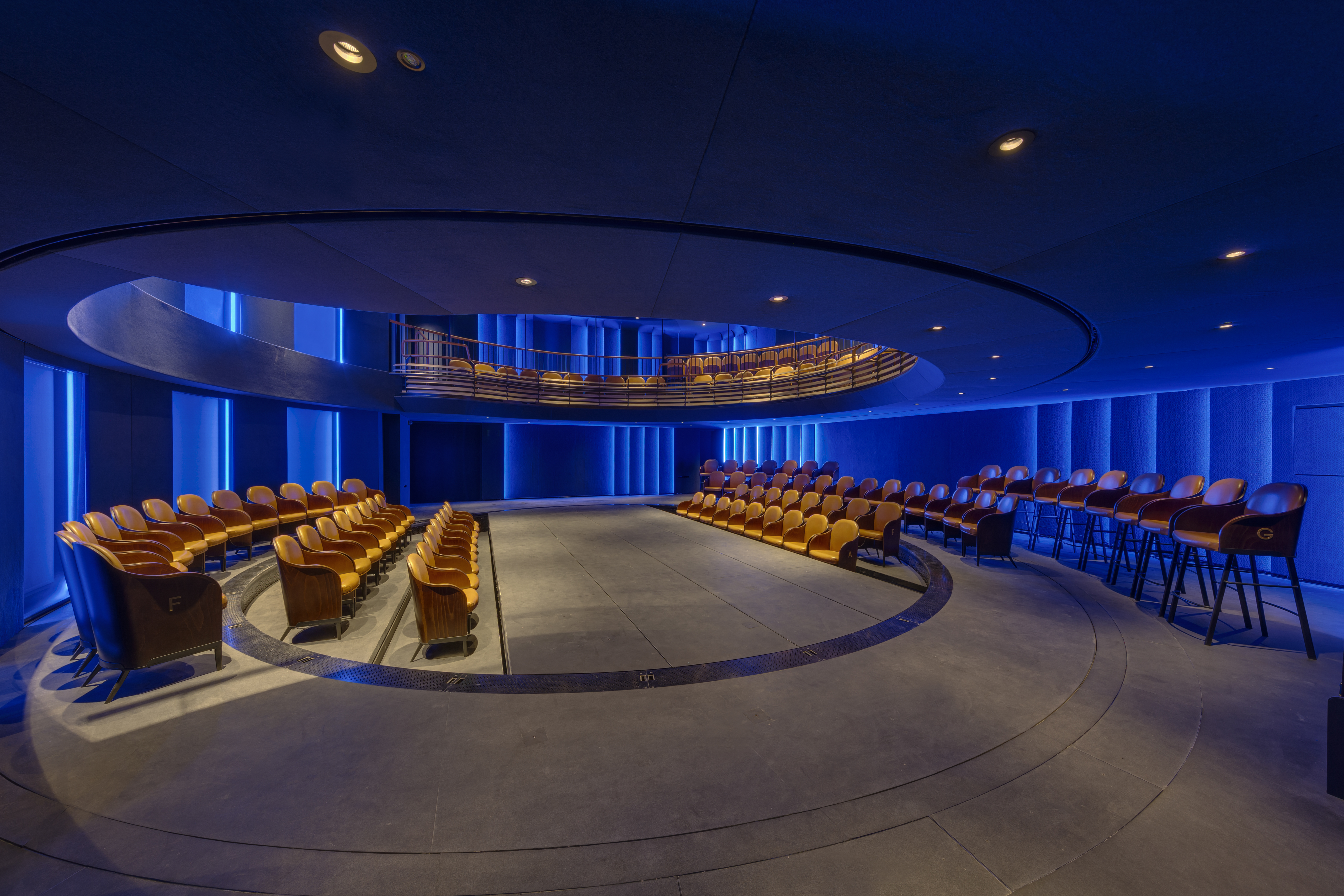 Modern auditorium with tiered seating and blue lighting for corporate events. - Banner