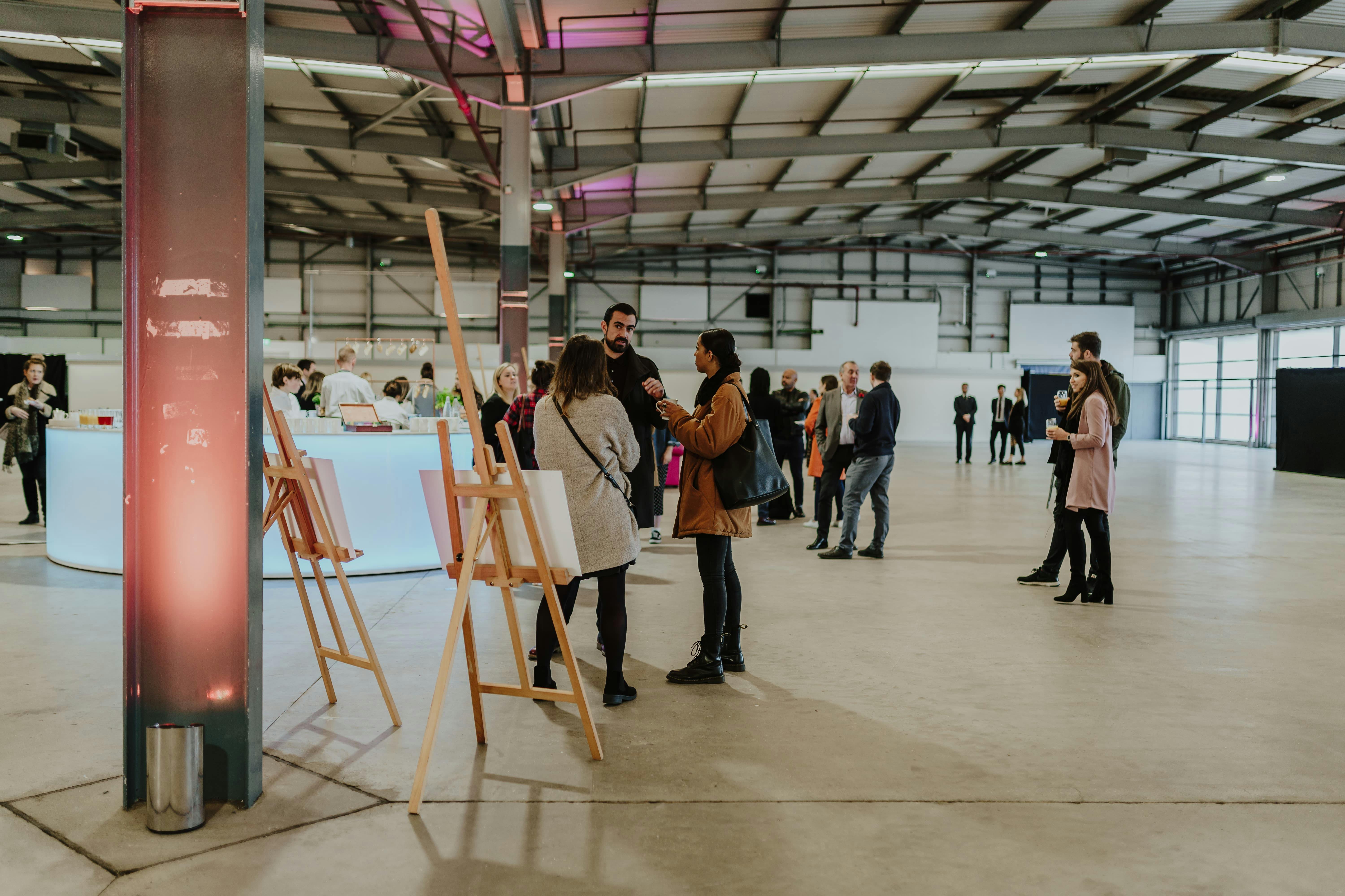 Spacious Dock X London venue with attendees networking at a modern event.