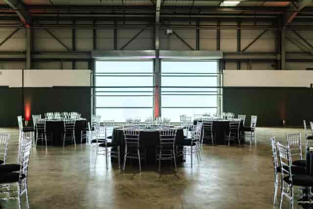 Spacious Dock X London venue with elegant round tables for formal events.