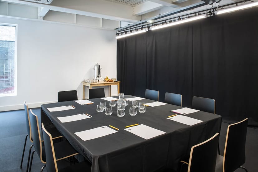 Modern rehearsal room with black tablecloth for meetings and presentations.