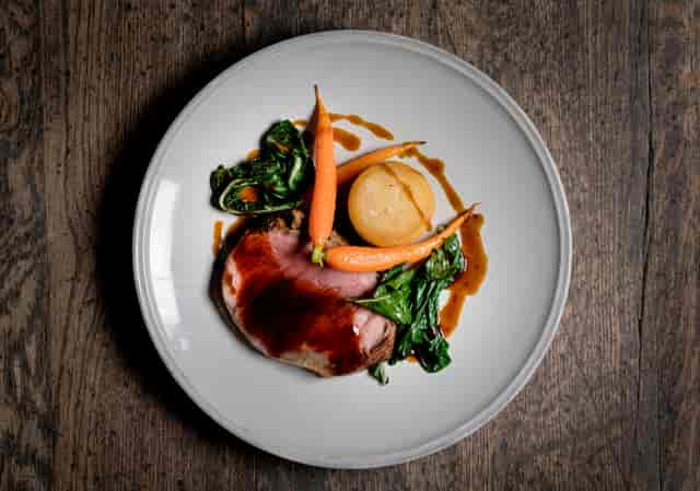 Succulent roasted meat dish with baby carrots at Swan at The Globe event venue.