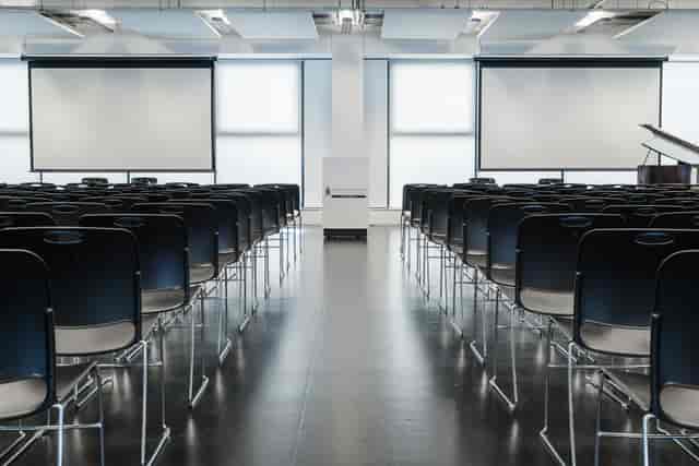 Main hall at London Academy of Excellence Tottenham, modern event space with black chairs.