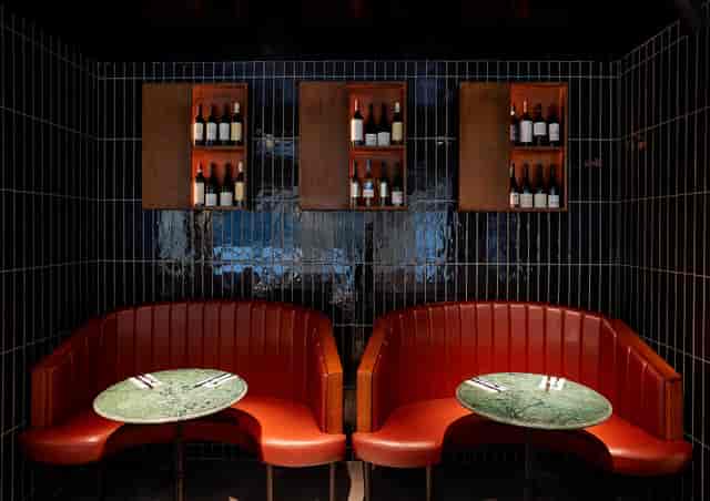 Intimate seating area with red booths in Gunpowder Tower Bridge for networking events.