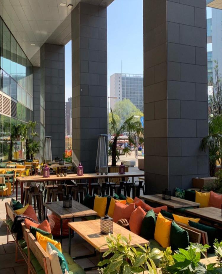 Vibrant outdoor event space at FoodWell with modern architecture and ample seating.