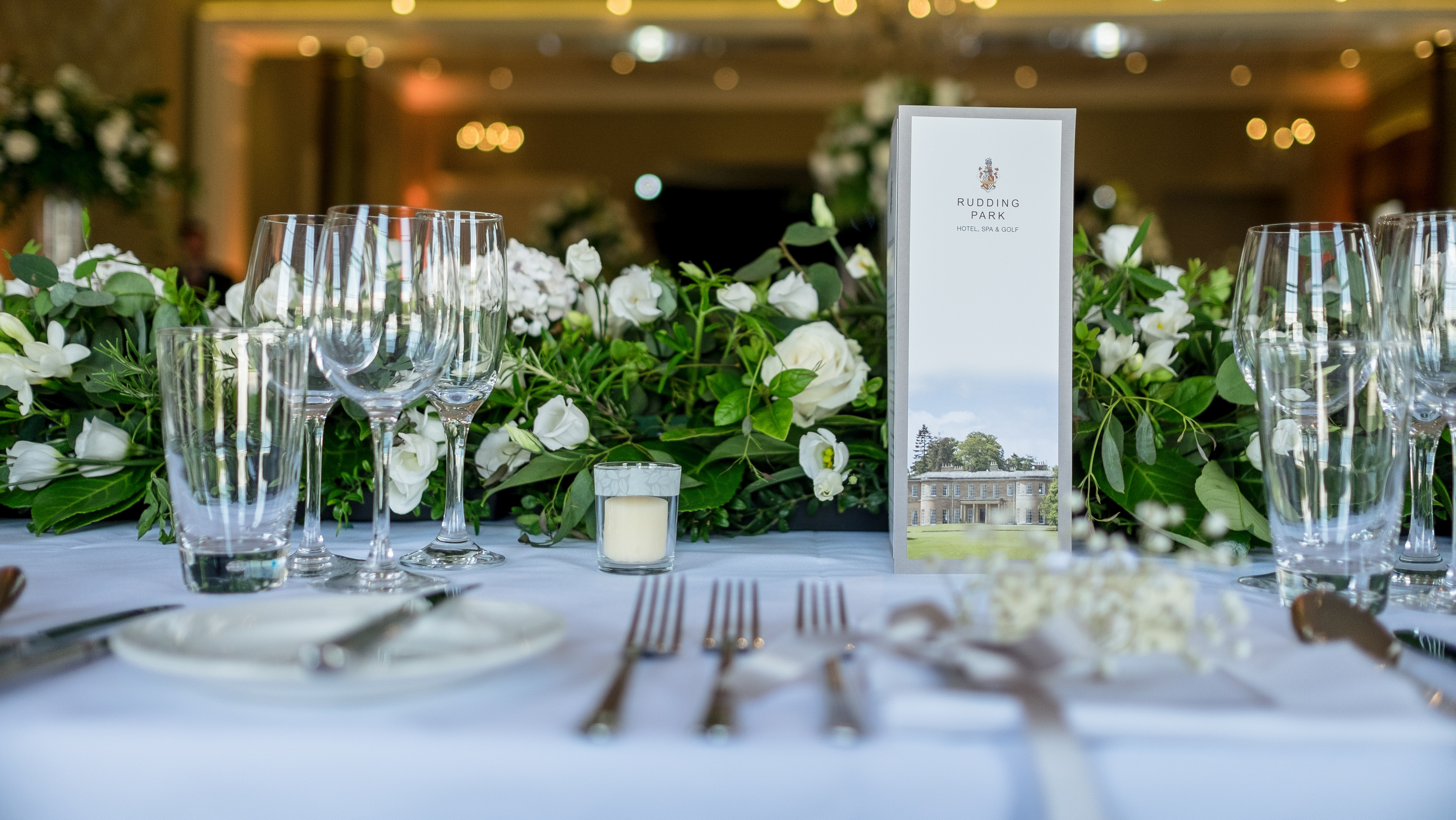 Elegant dining table setup with floral centerpieces for events at Rudding Park. - Banner