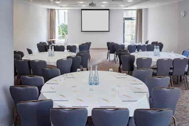 Claremont Suite meeting space with round tables, ideal for professional events and networking.
