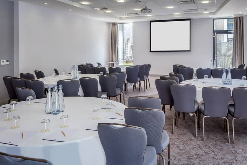 Claremont Suite meeting space with round tables for collaboration at DoubleTree London.