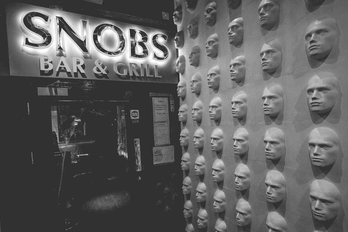 VIP Mezzanine Suite entrance with sculpted faces at Snobs Bar & Grill for memorable events.