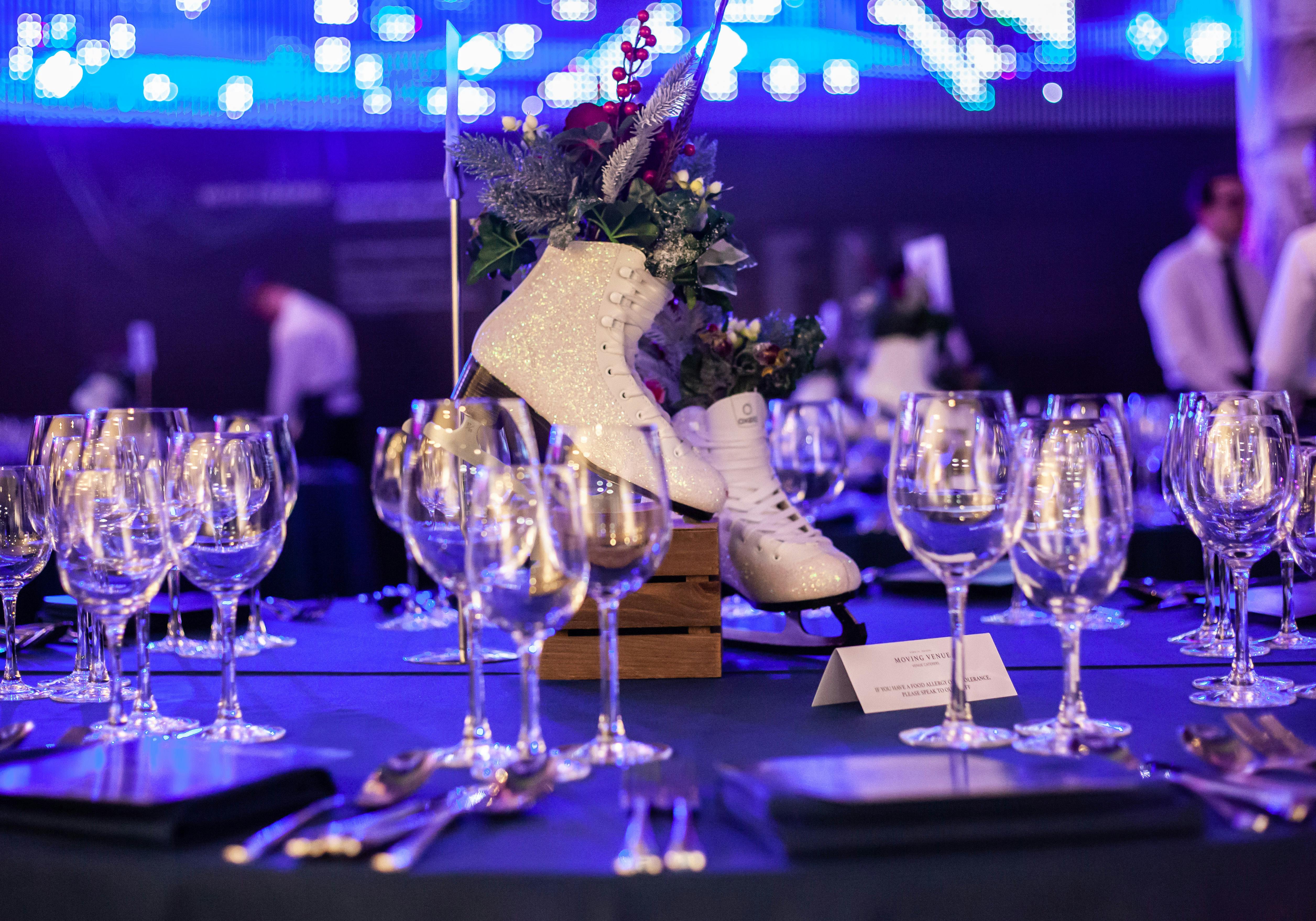 Elegant table setup with ice skate centerpiece at London Ellipse Hall winter event.