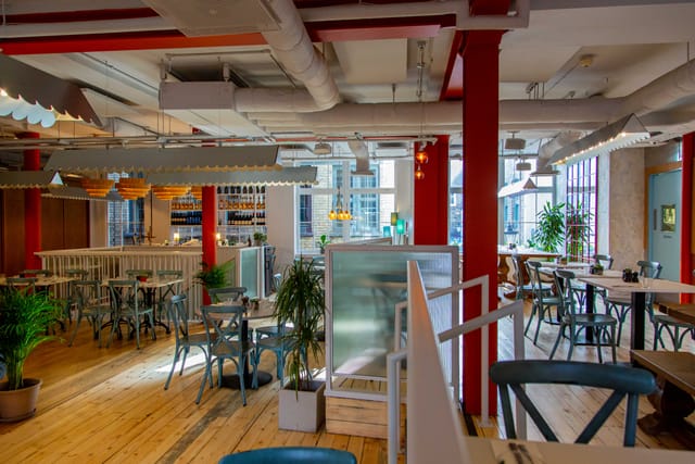 Modern open-concept event space with natural light in Paradiso Soho for meetings and gatherings.