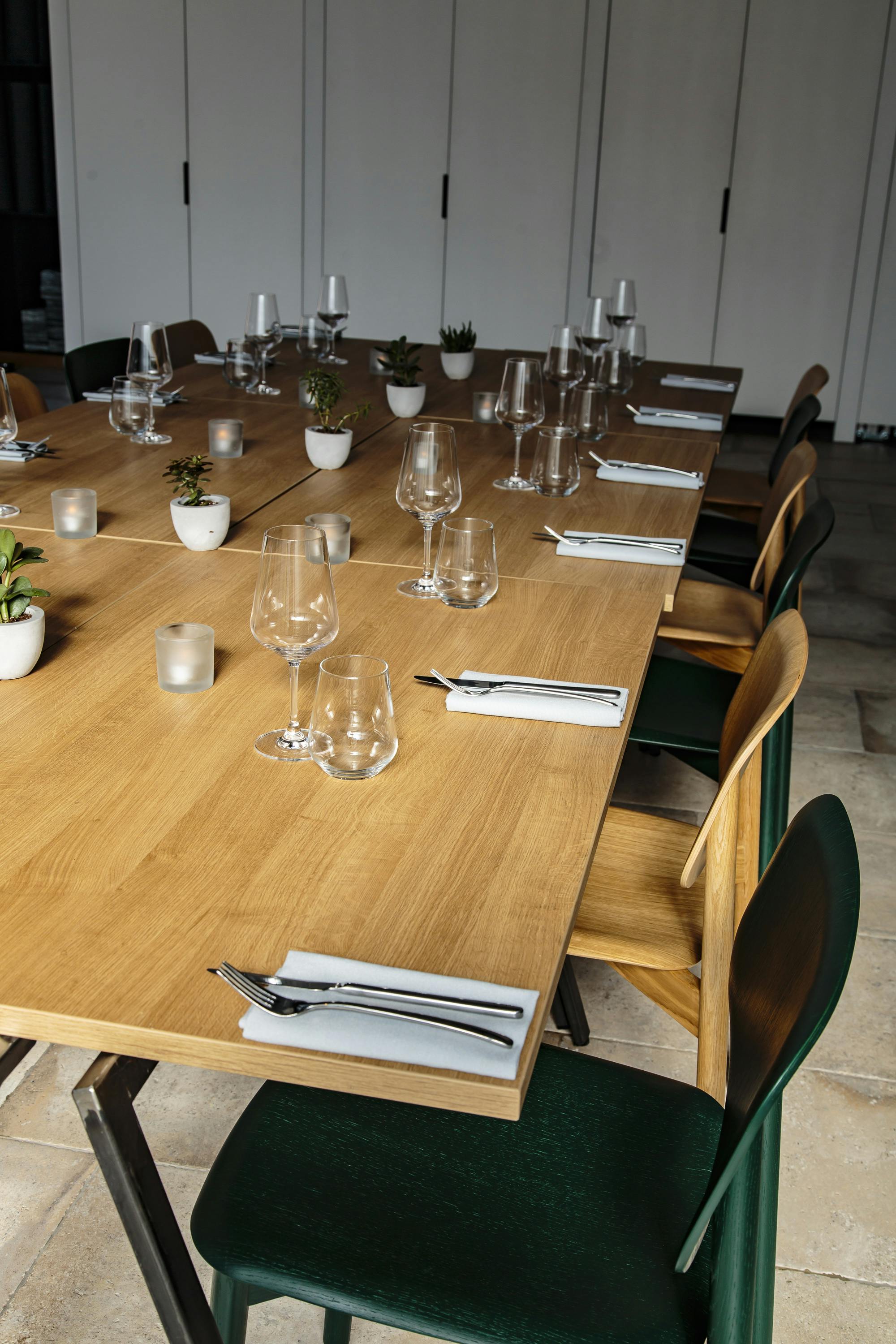 Intimate dining setup with elegant glassware and natural wood finish for events.